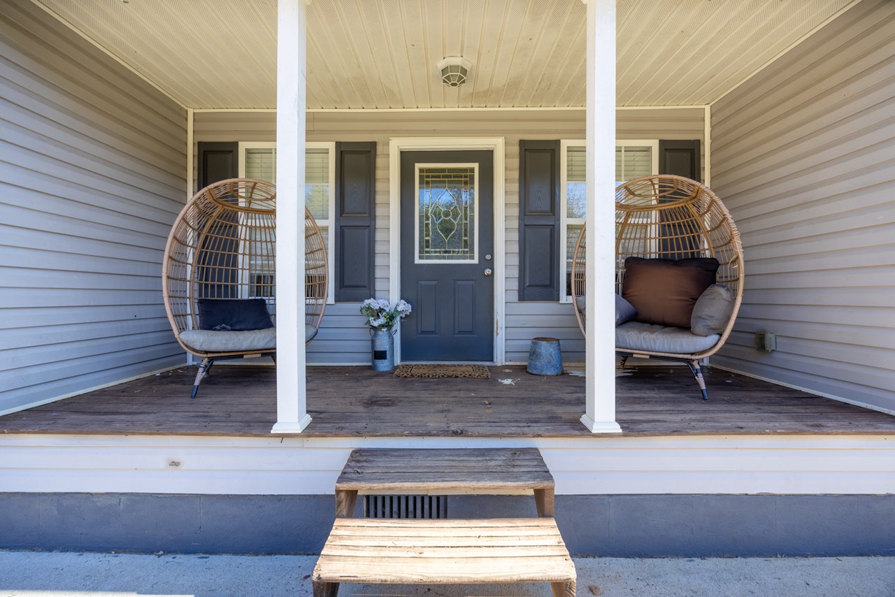 porch 2 wooden steps, columns, chairs, front door